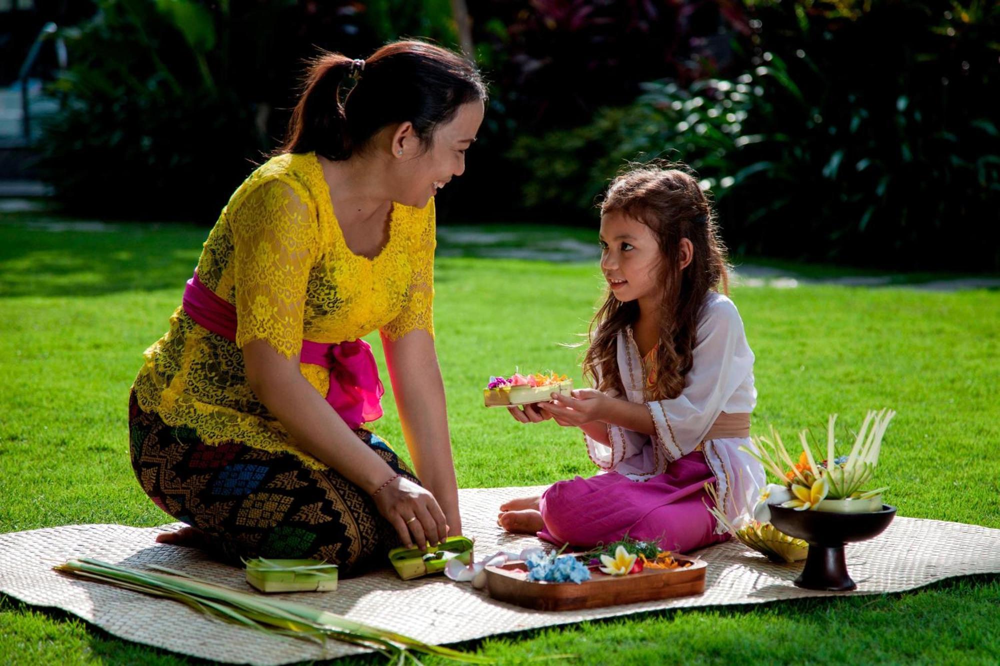 Courtyard By Marriott Bali Seminyak Resort מראה חיצוני תמונה A Balinese Hindu woman and her daughter preparing offerings.